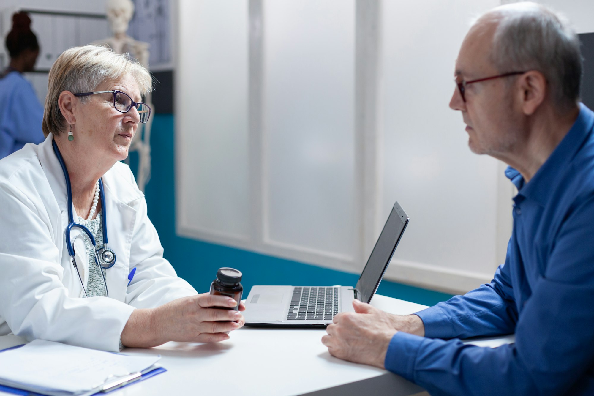 Woman medic giving bottle of pills to aged man with illness